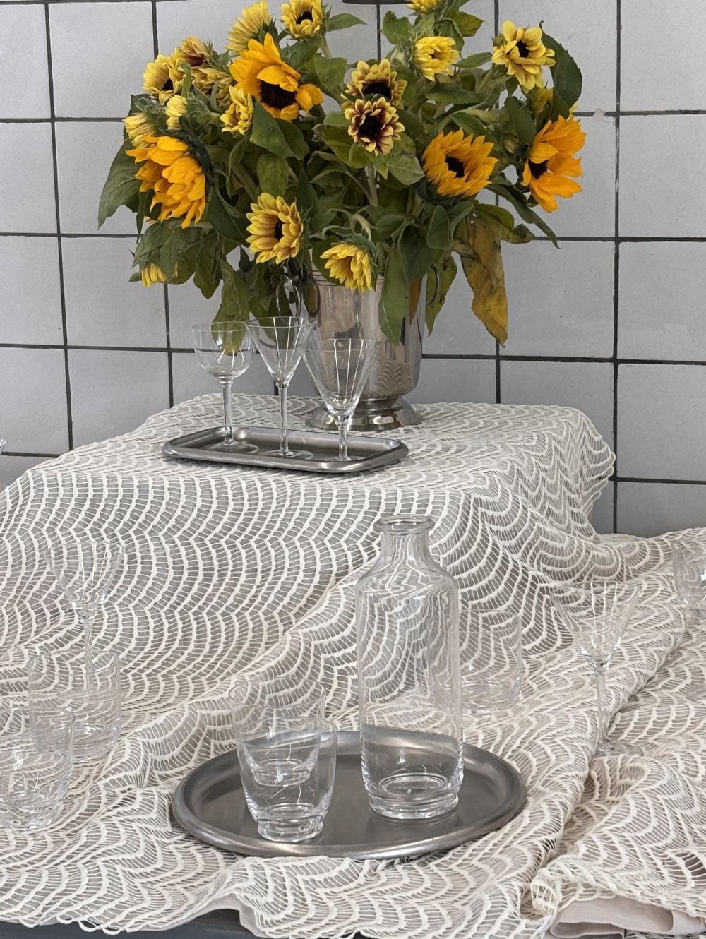 Bord dækket med stålservice og vase med solsikker