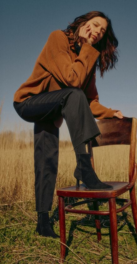 Kvinde på mark med benet oppe på stol