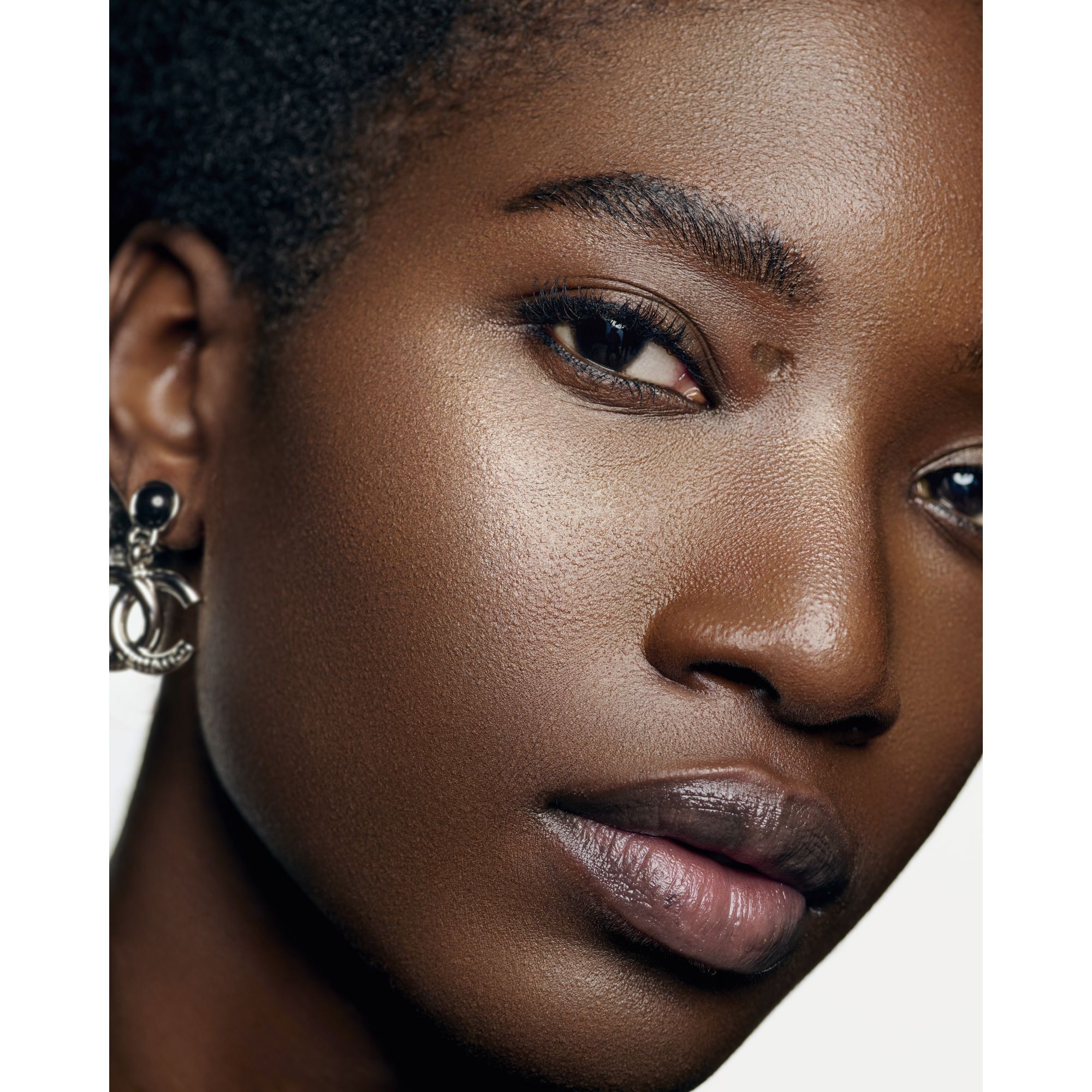 LET TRANSPARENT OG LYSGIVENDE FLUID MED IRISERENDE EFFEKT