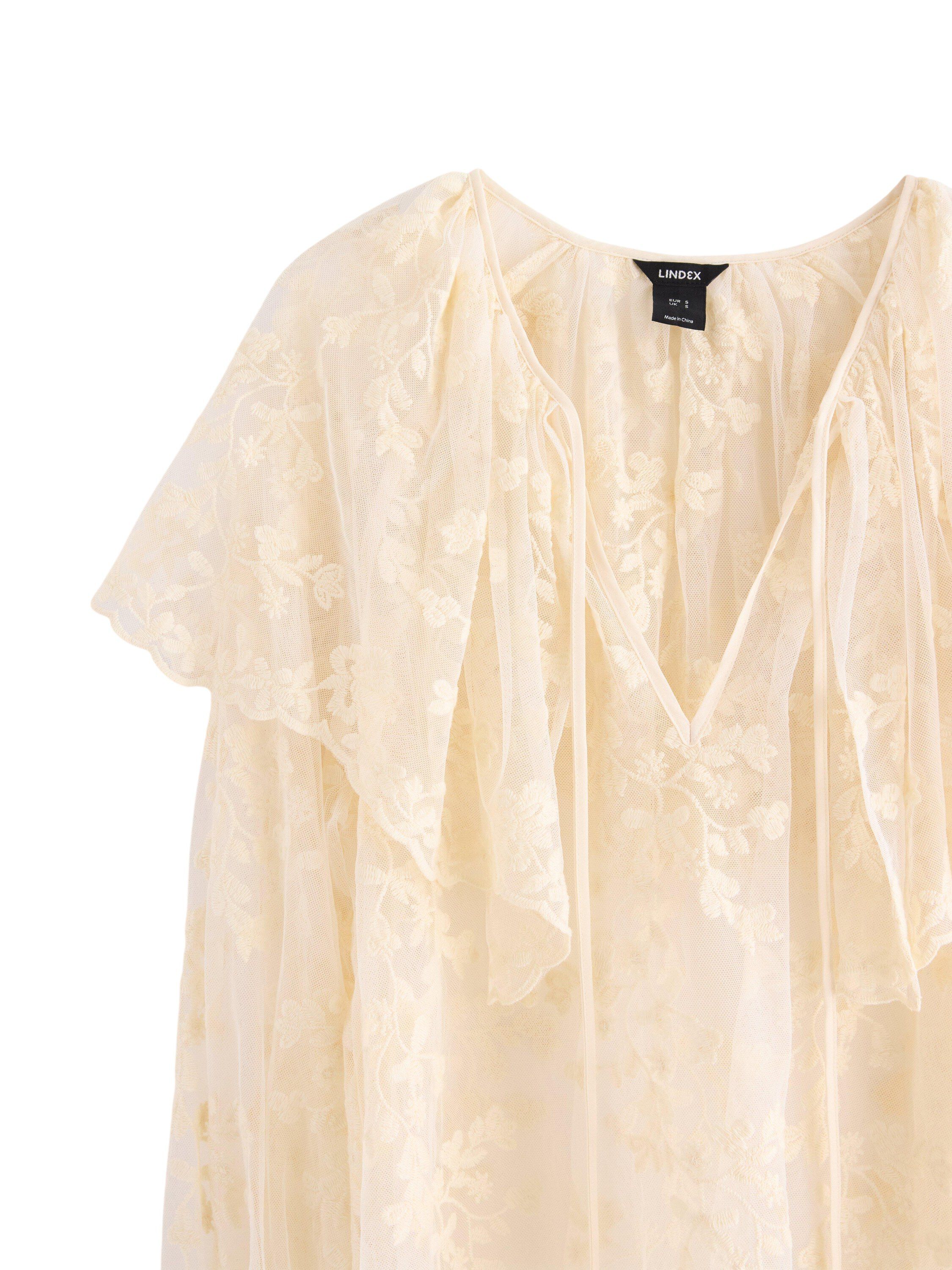 Sleeveless blouse in lace and mesh.