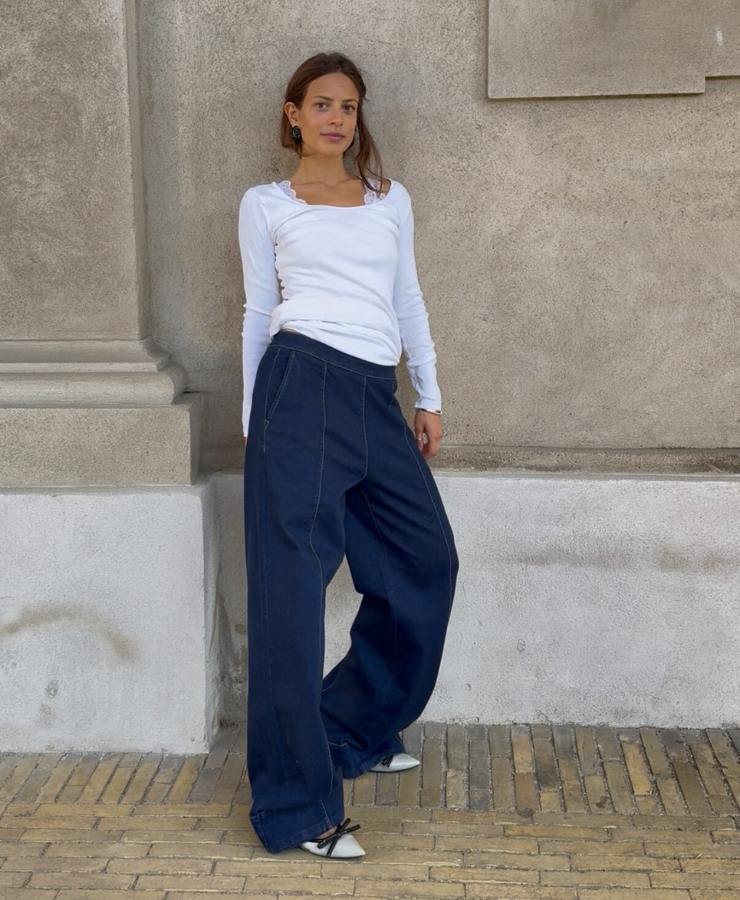 kvinde iført jeans står opad mur