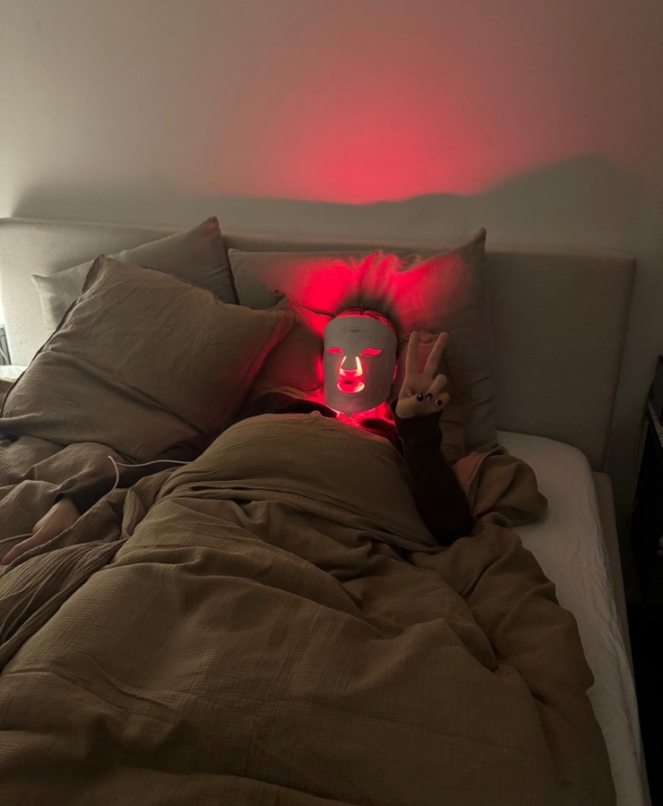 kvinde ligger i seng med rød maske på