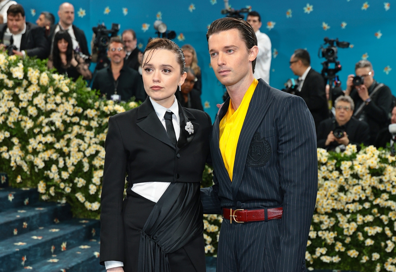 Kvinde og mand står iført jakkesæt på den røde løber til MET Gala